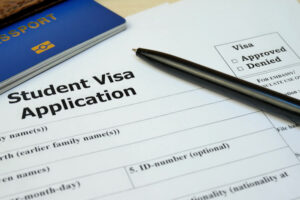 student visa application form with passport and pen